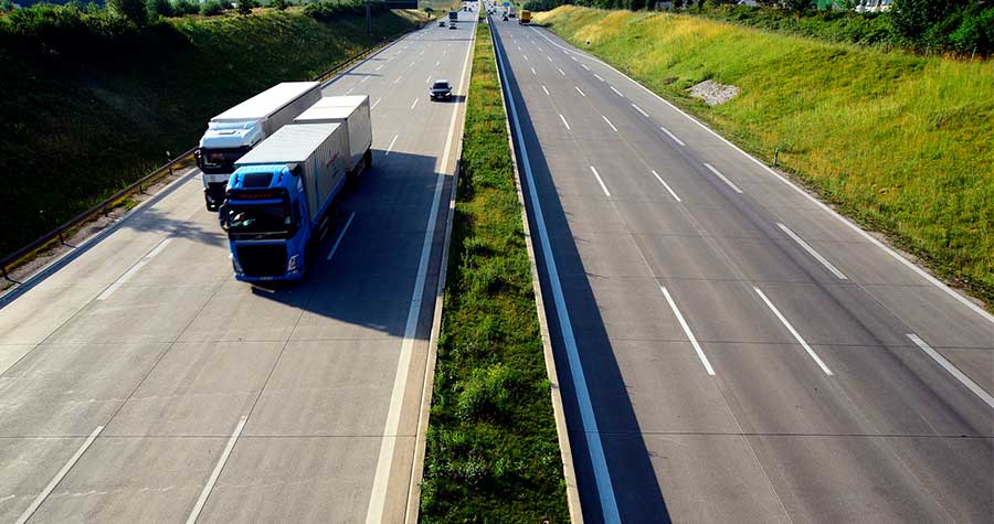 caminhão transitando por estrada realizando o transporte de eletrodomésticos
